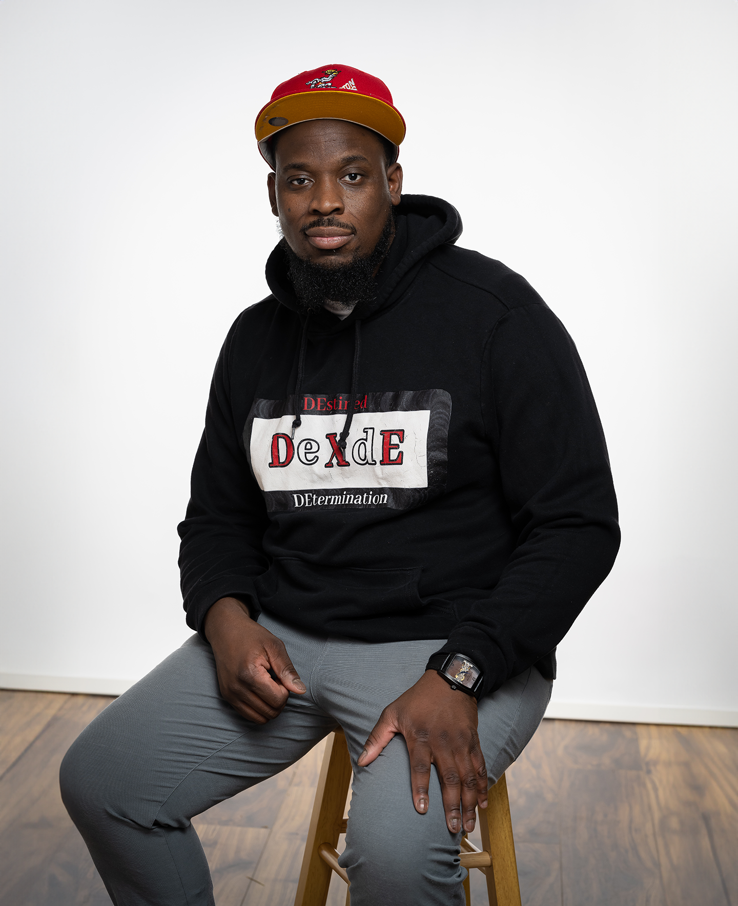 G Dash Jones seated in a red cap and black hoodie